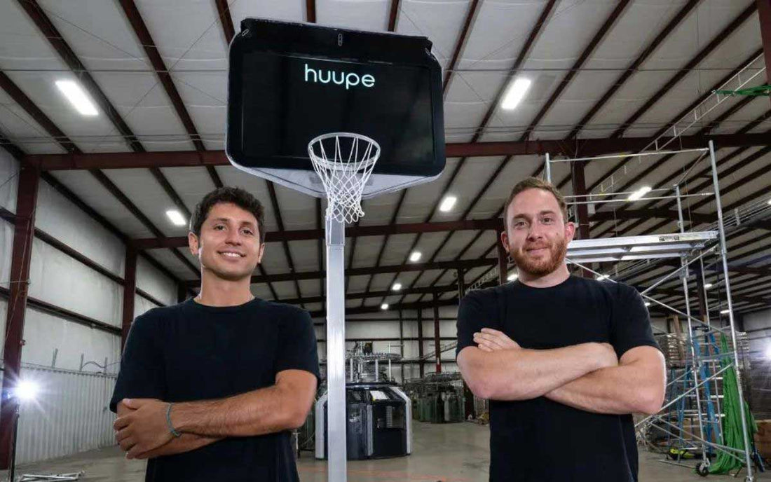 Co-founders smiling next to each other in front of the huupe